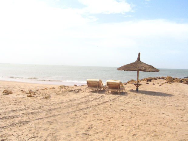 Praia com duas cadeiras e chapu