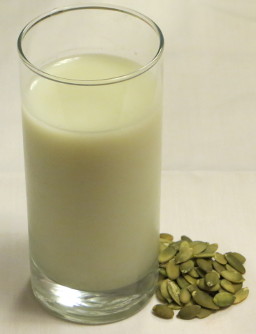 copo de leite de sementes de abóbora com sementes ao lado